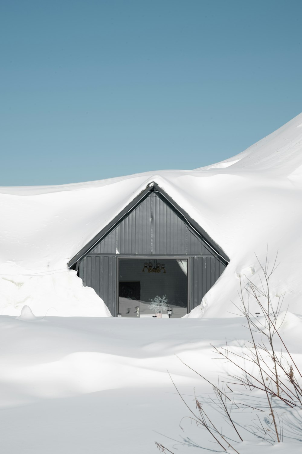 a barn sitting in the middle of a snow covered field