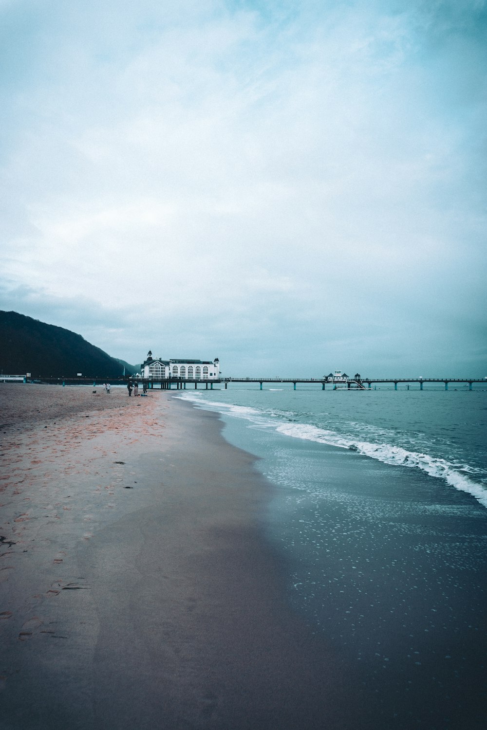 a beach with a pier in the background