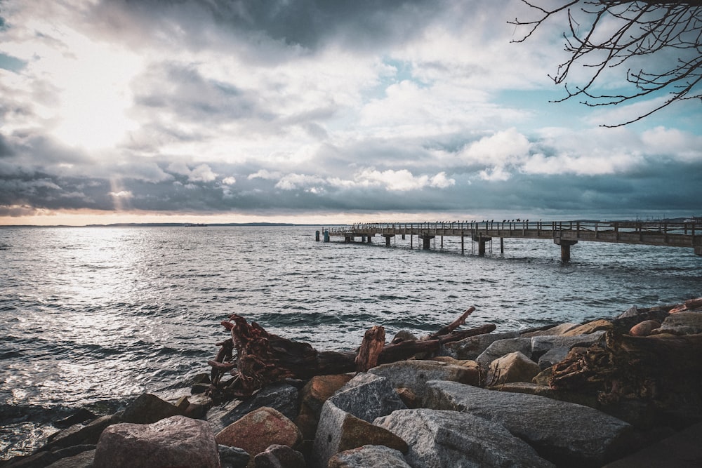 a pier on a cloudy day over a body of water
