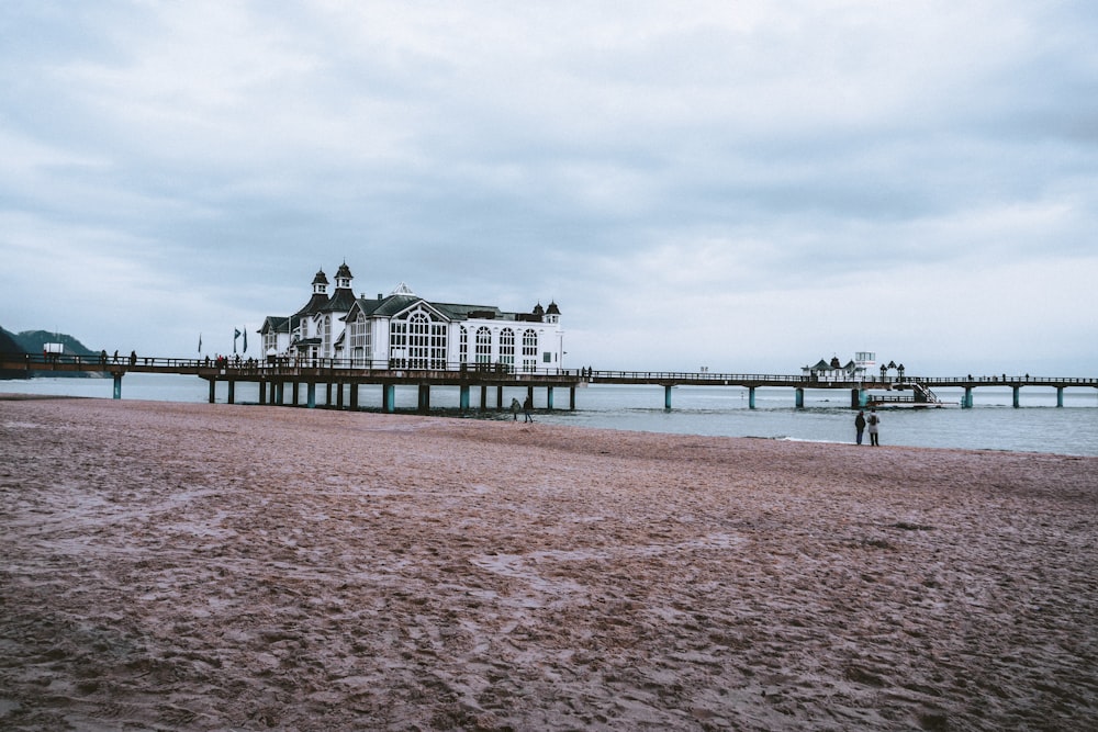 a man standing on a beach next to a pier