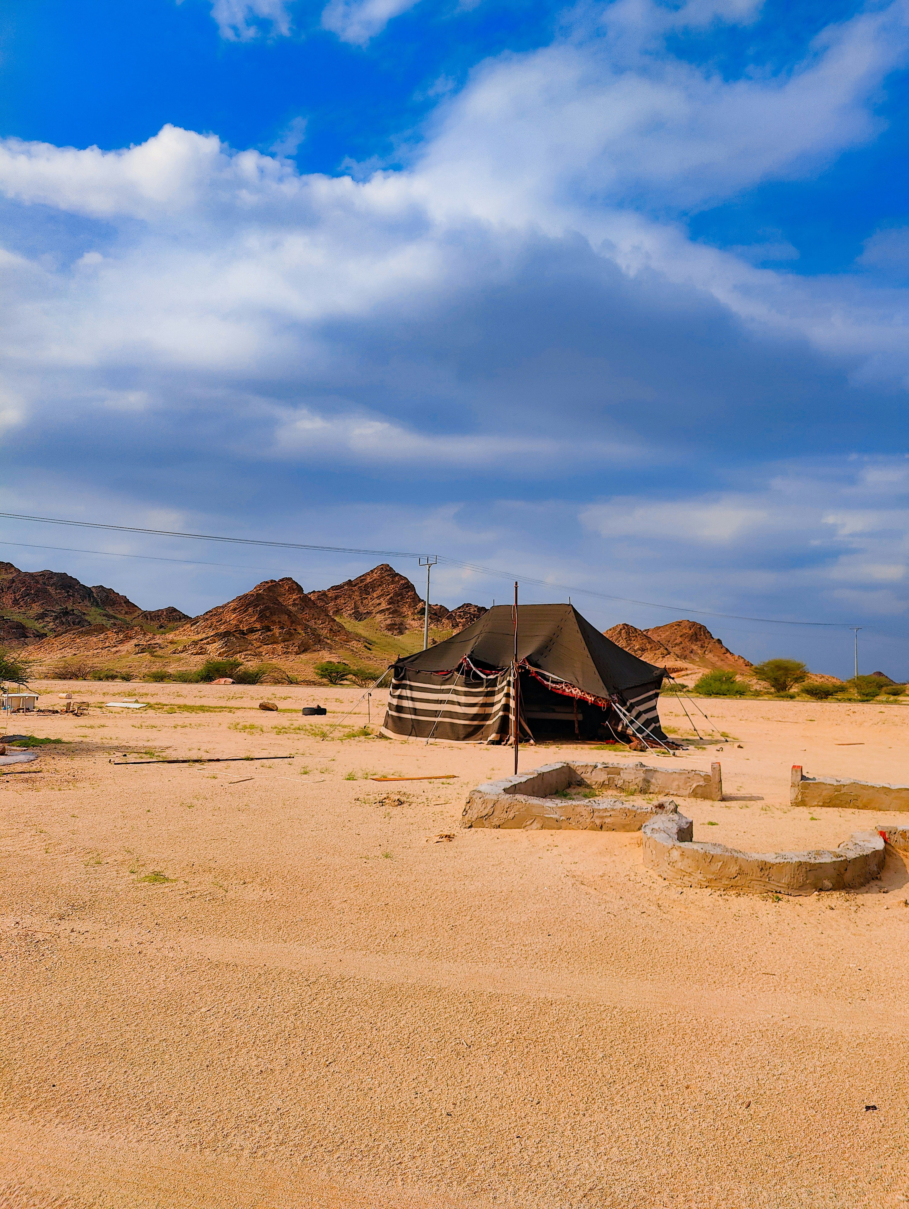Traditional Bedouin beach camp with colorful cushions and fire pit under starry Sinai sky