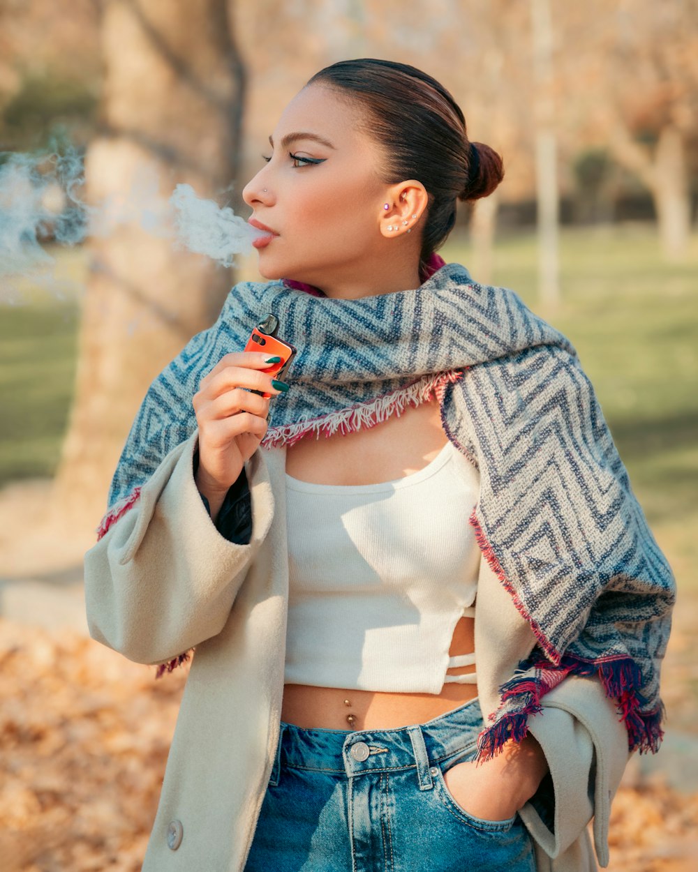 a woman smoking a cigarette in a park