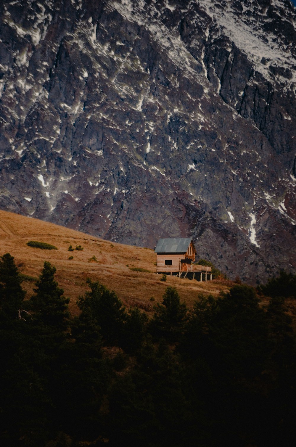 uma casa em uma colina com uma montanha ao fundo