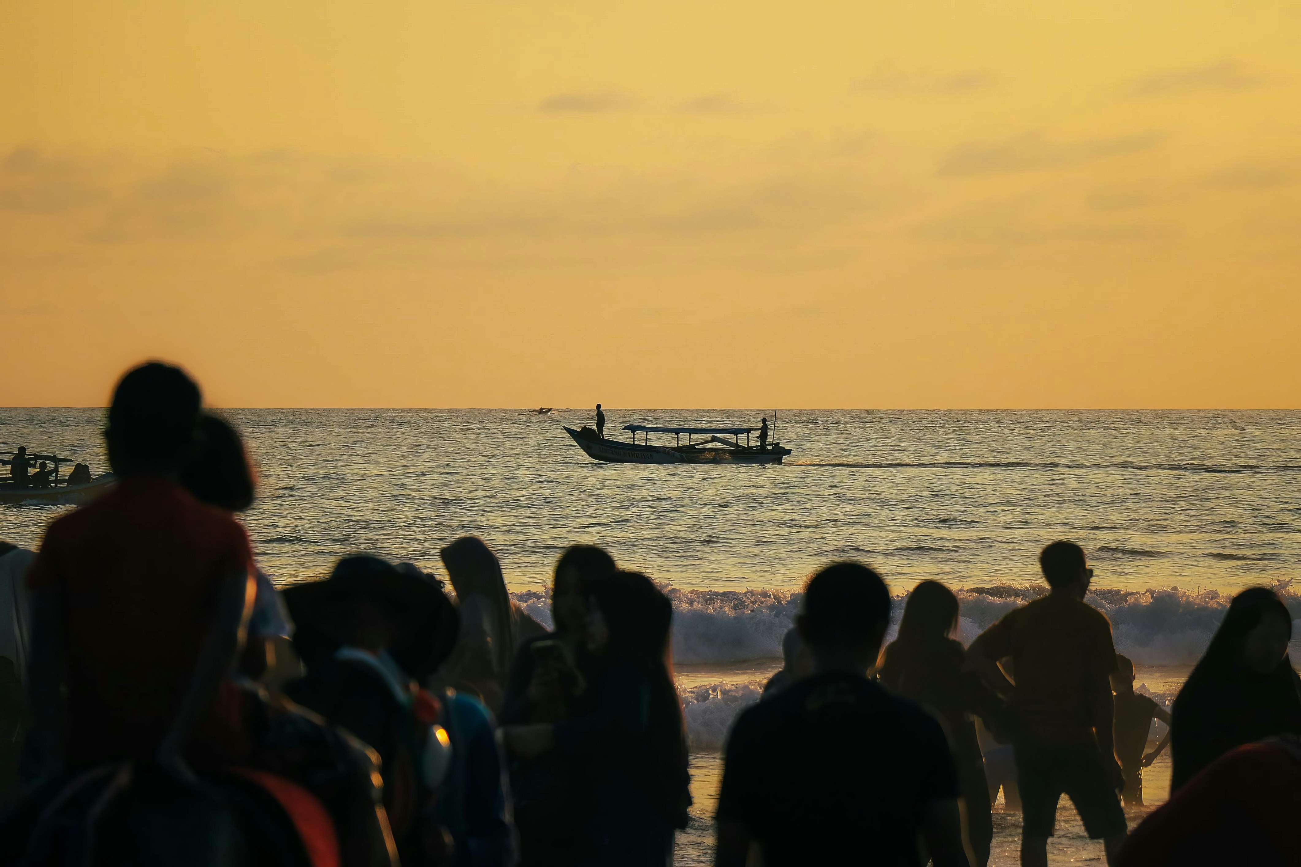 sekelompok orang berdiri di atas pantai di sebelah laut