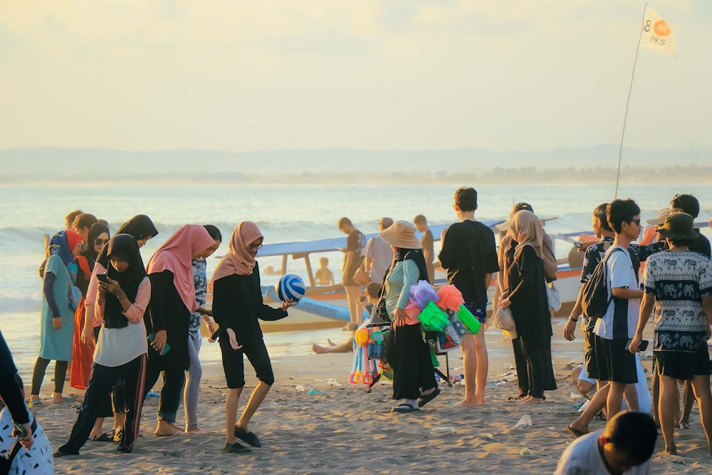 a group of people standing on top of a sandy beach