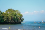 a group of people on a beach with boats in the water