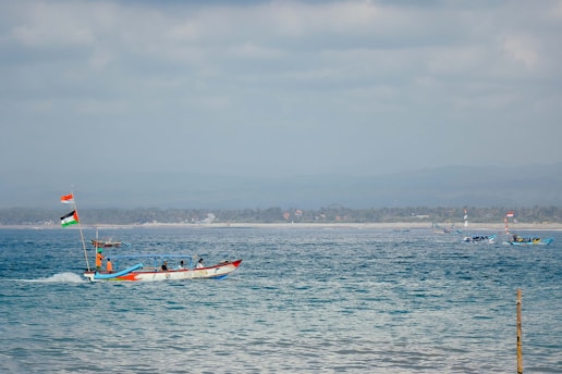 a boat with a flag is in the middle of the ocean