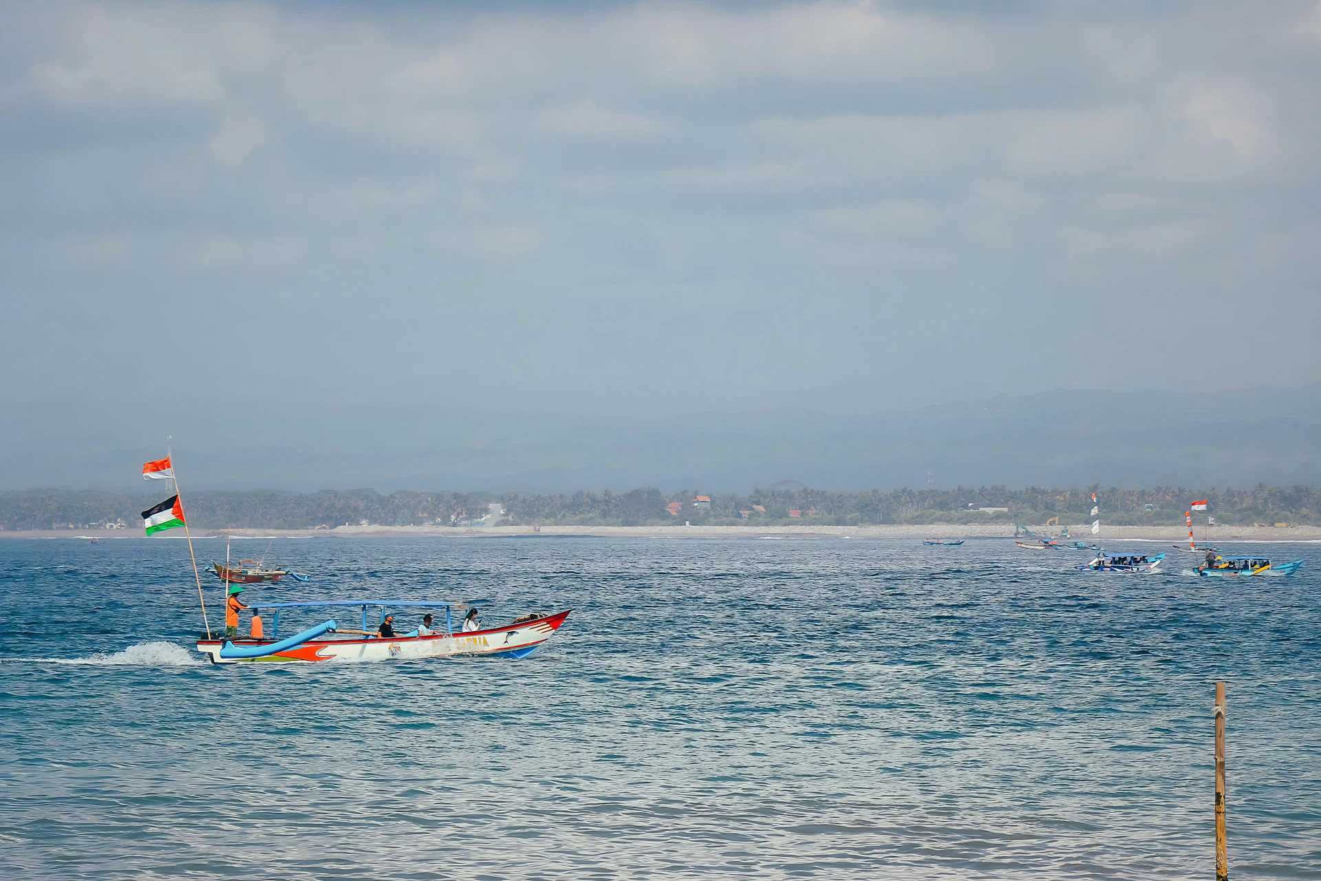 a boat with a flag is in the middle of the ocean