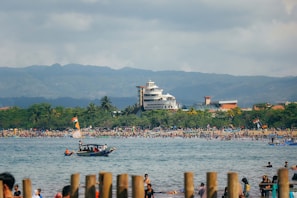 a group of people standing on a beach next to a body of water