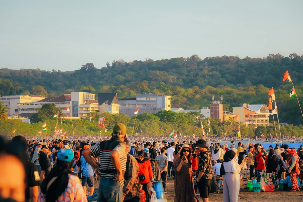 a crowd of people standing on top of a beach