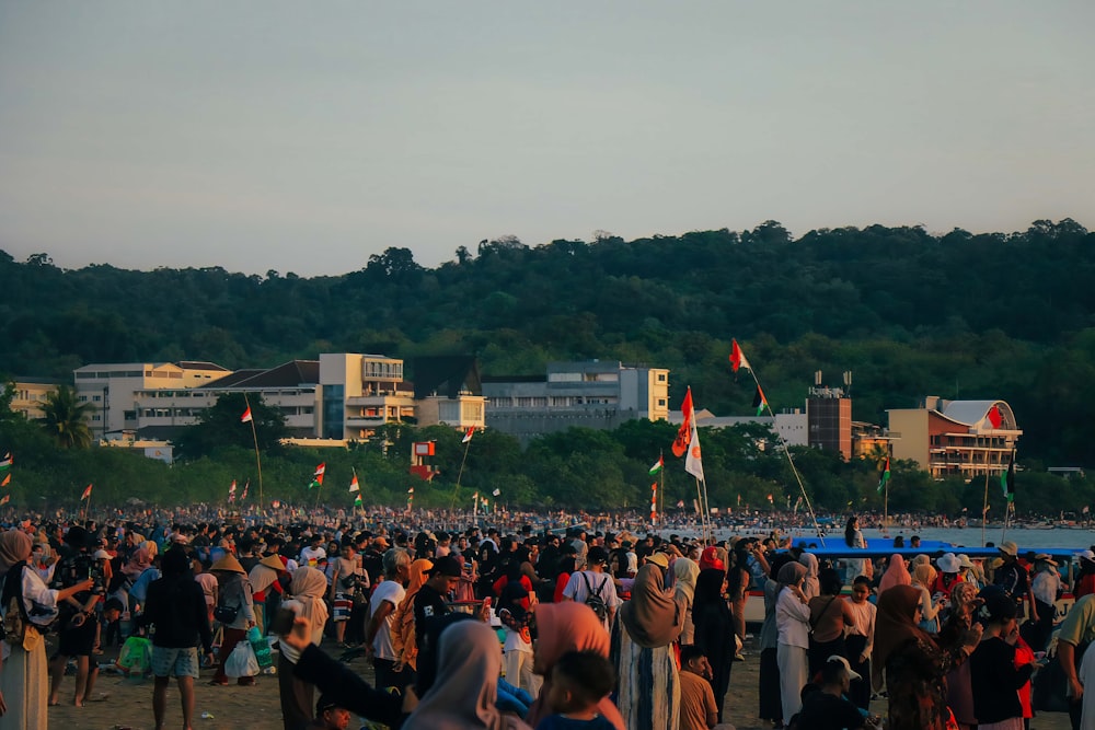 a crowd of people standing on top of a beach