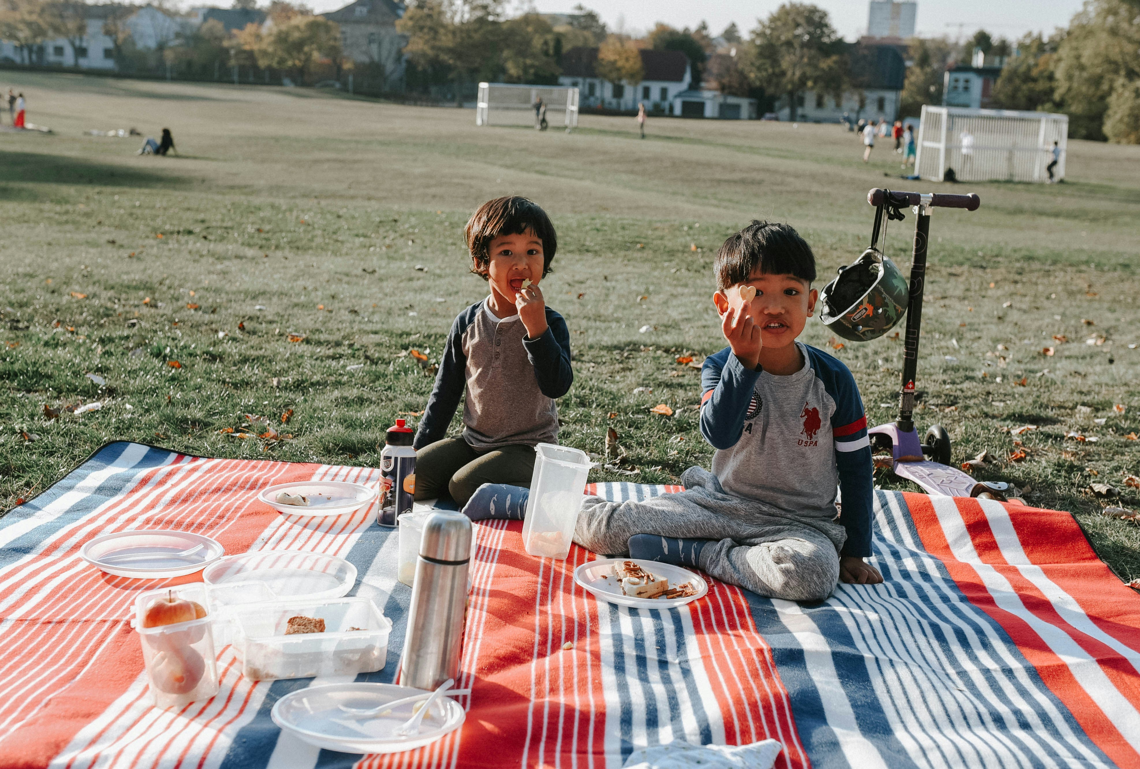 A joyful family enjoying a picnic on the grass at an outdoor community concert, with children dancing and adults relaxing to the sounds of live music on a sunny day - chicago suburbs live music