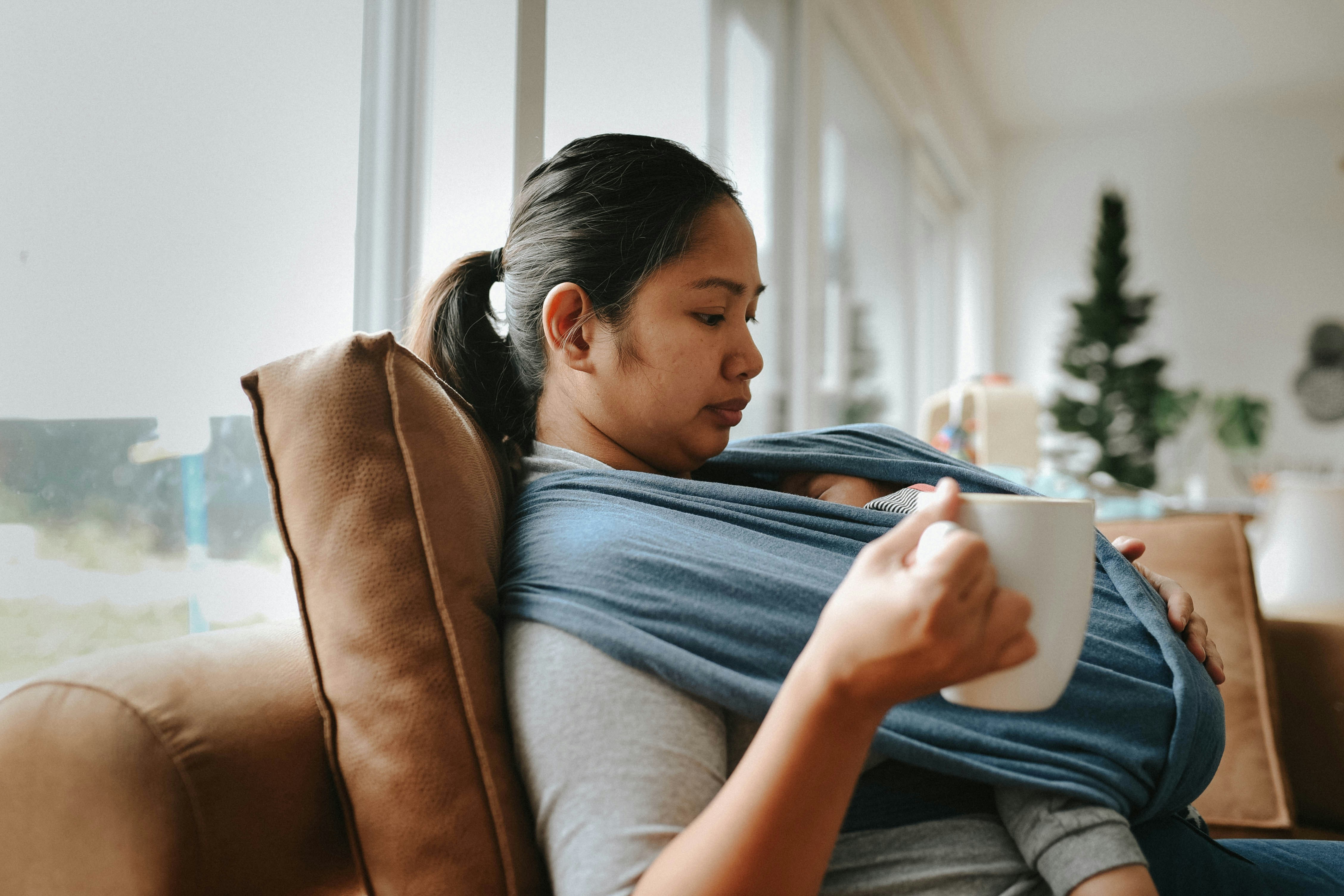 a woman sitting on a couch holding a cup