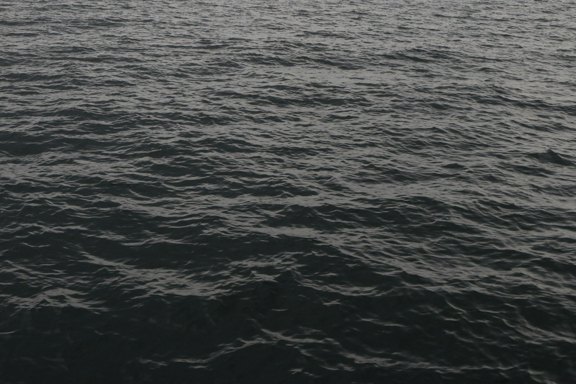 a large body of water with a boat in the distance