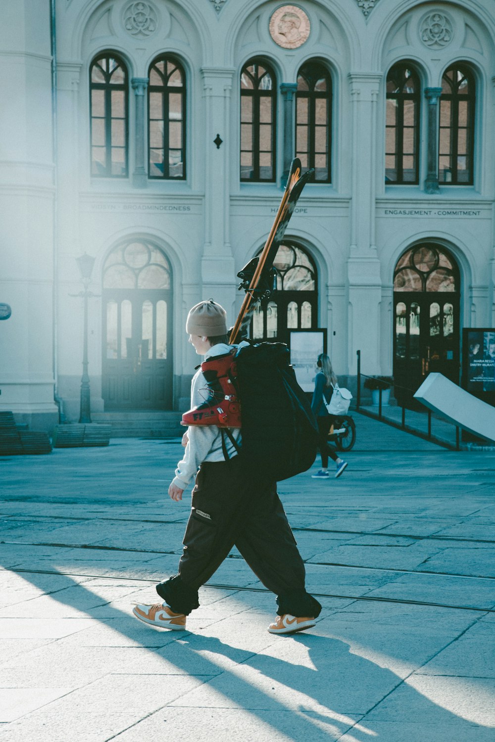 a person walking with a backpack and a baseball bat