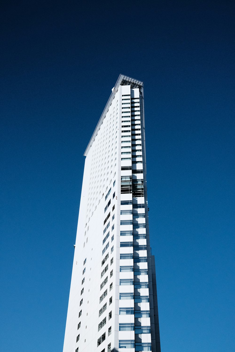 a tall white building with a sky background