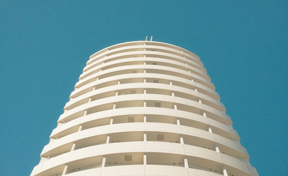 a tall white building with a blue sky in the background