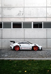a white sports car parked in front of a building
