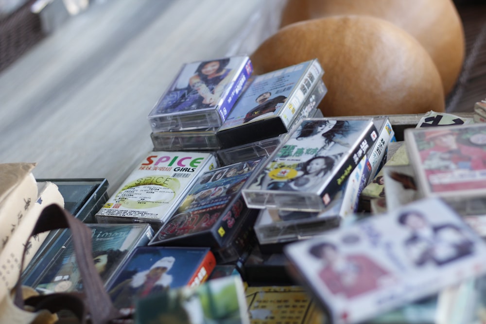 a pile of cds sitting on top of a wooden table