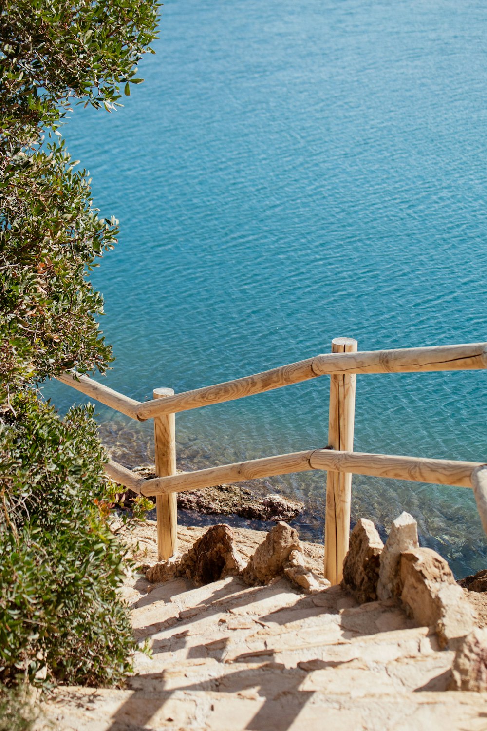 a wooden bench sitting on the side of a cliff