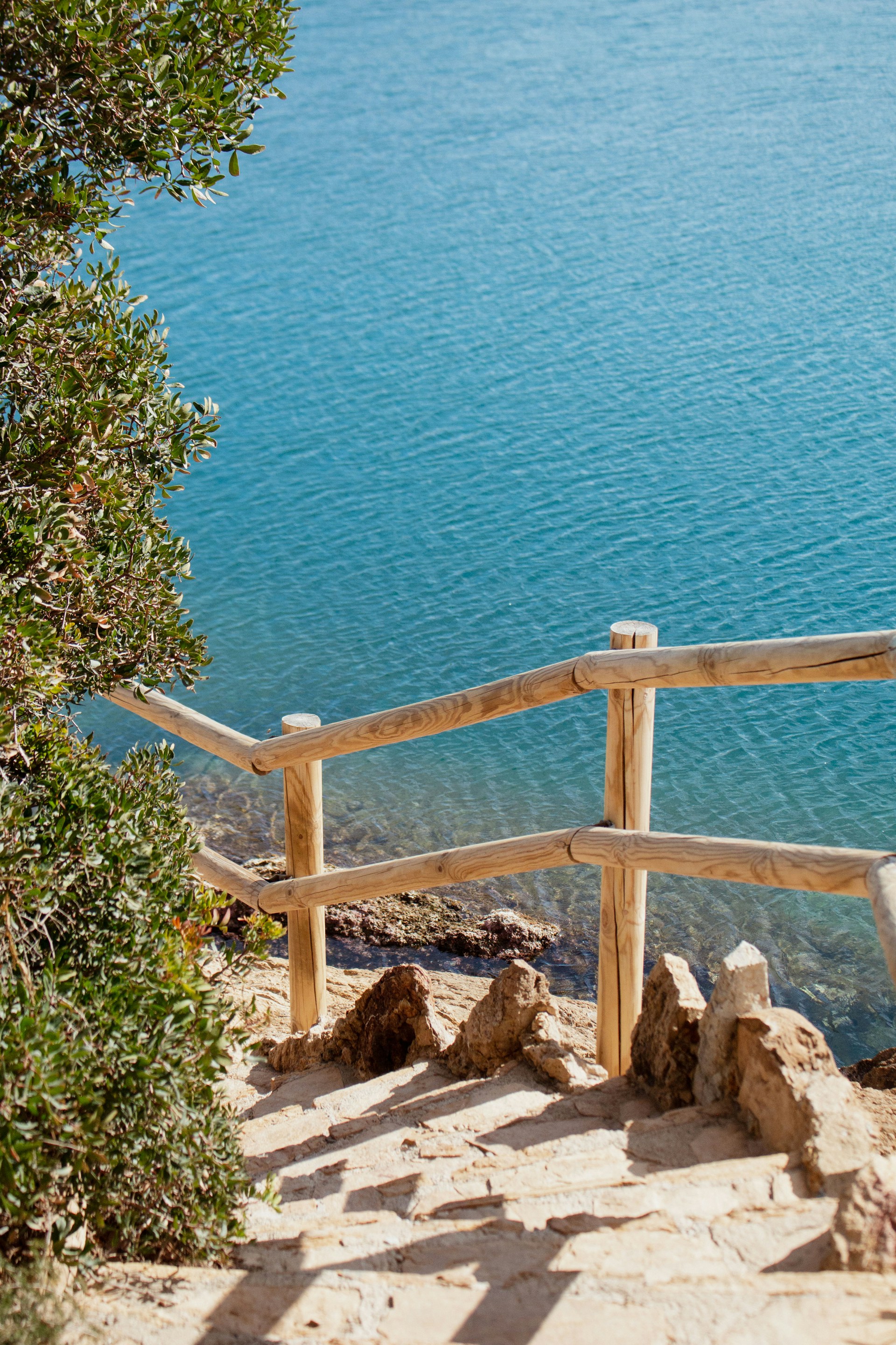 a wooden bench sitting on the side of a cliff