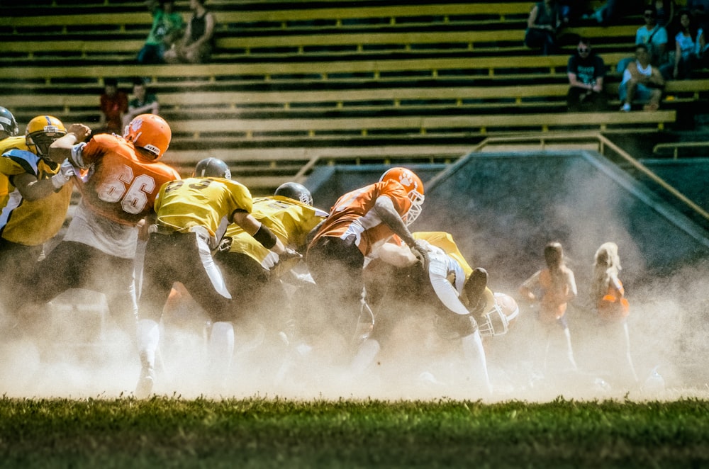 a group of football players running onto the field