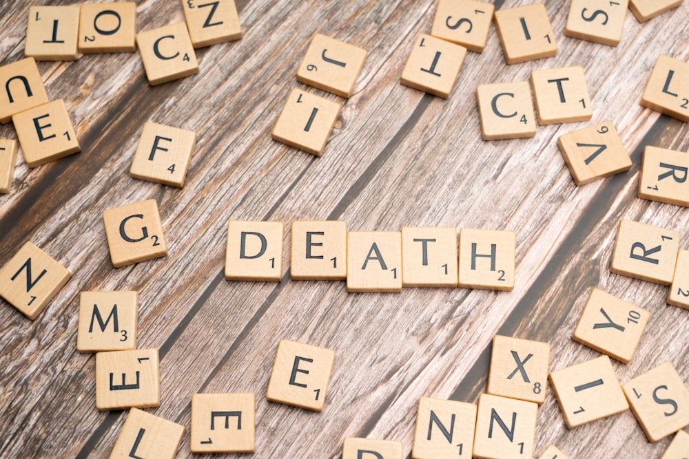 scrabble tiles spelling death and taxes on a wooden table