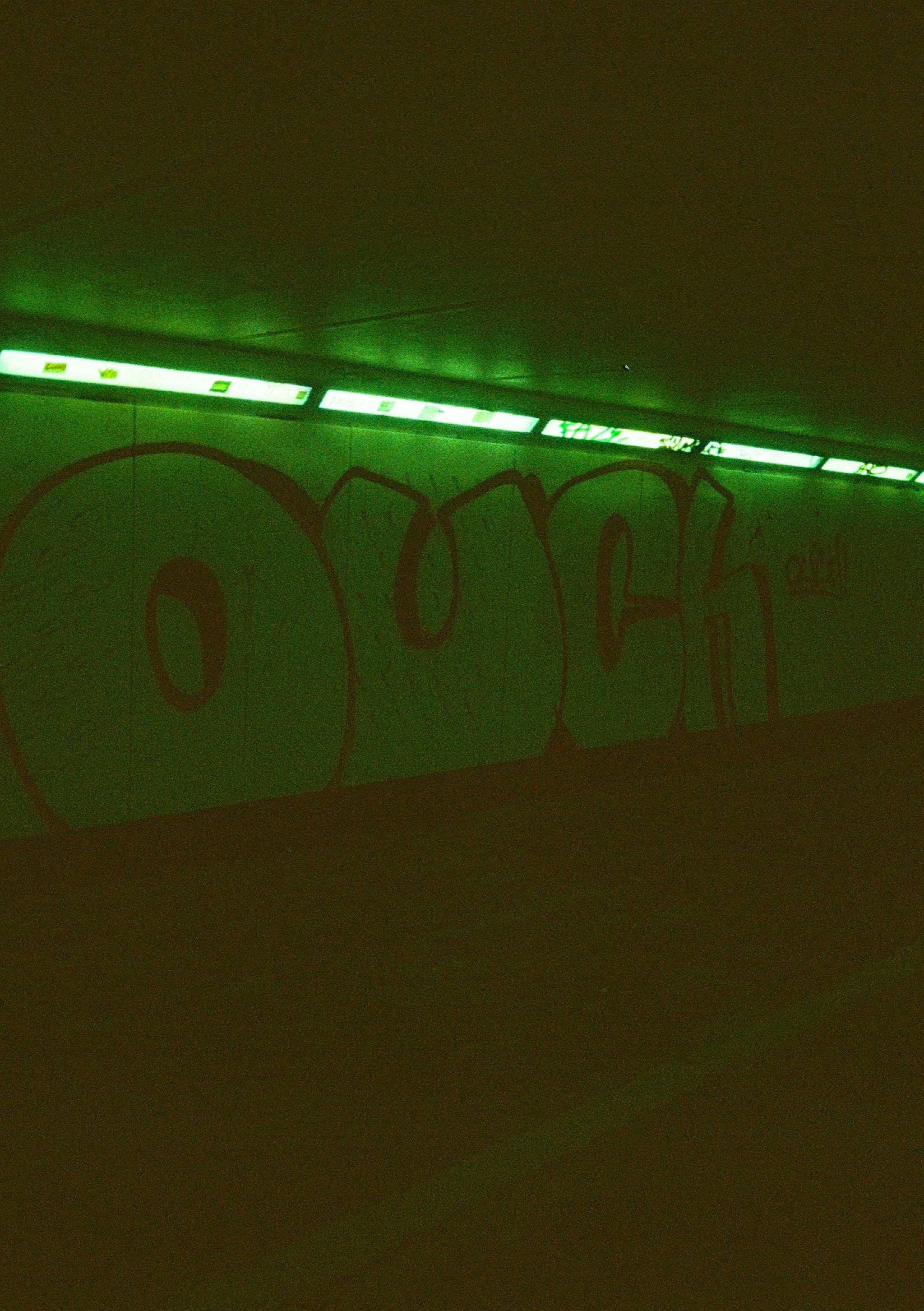 a wall with graffiti on it in a dark room