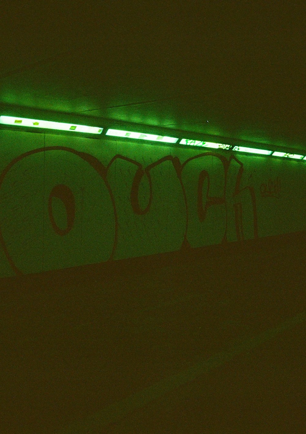 a wall with graffiti on it in a dark room