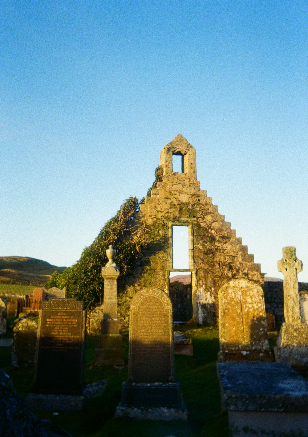 an old cemetery with a clock tower in the background