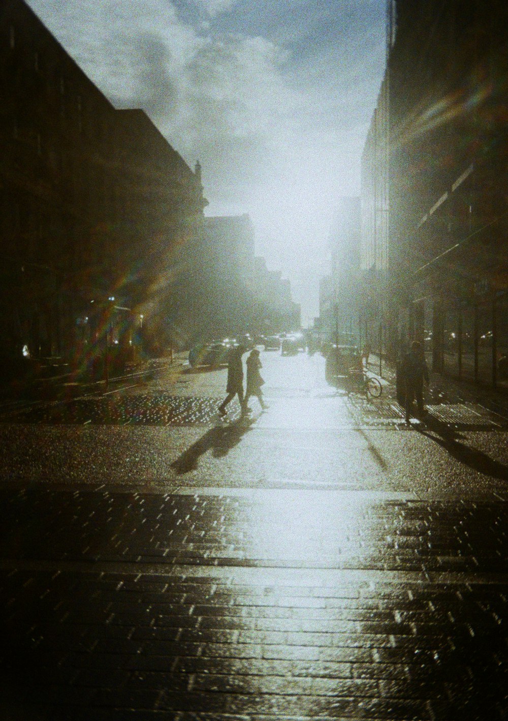 people walking down a city street in the rain