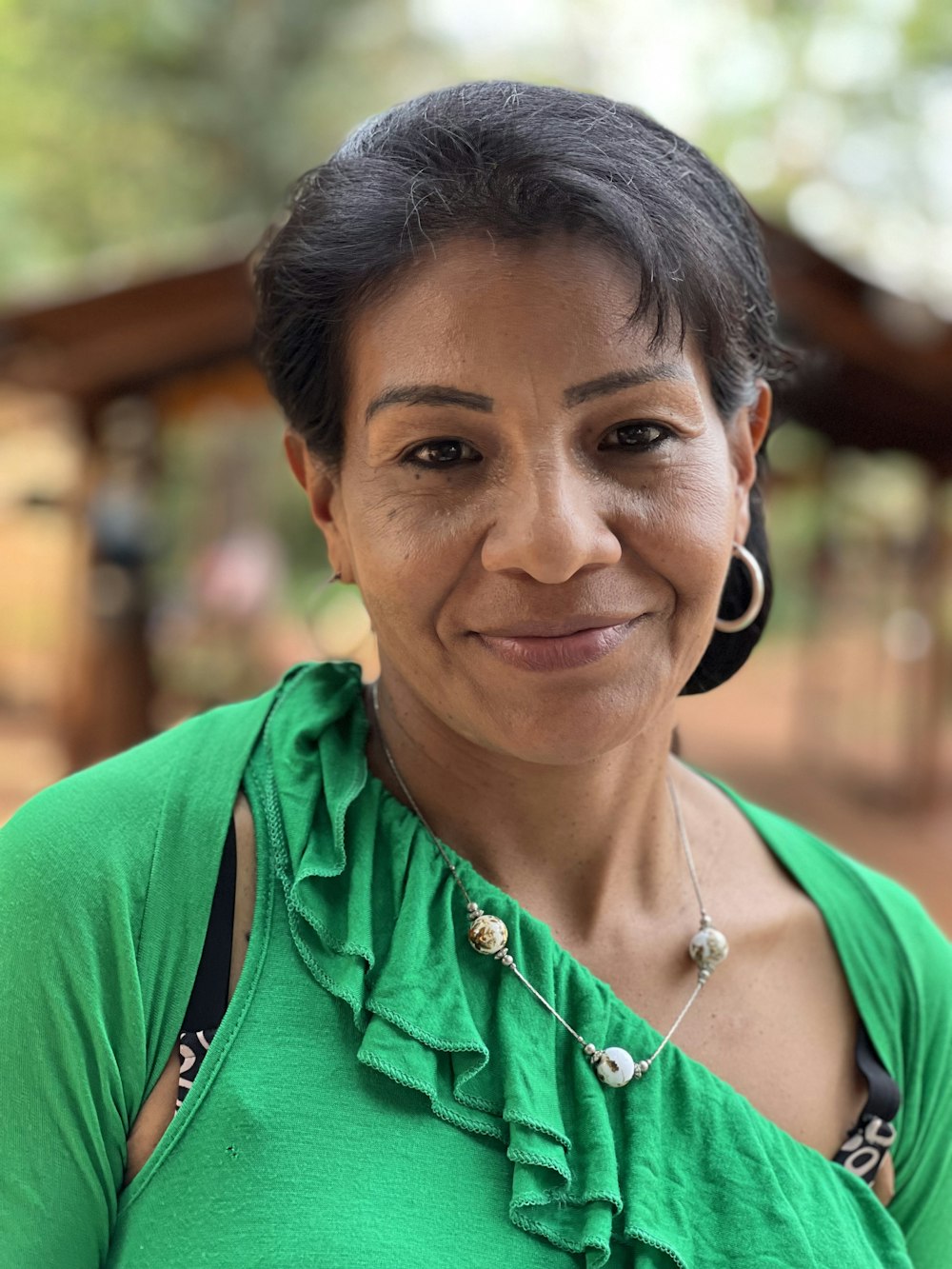 a woman in a green shirt is smiling