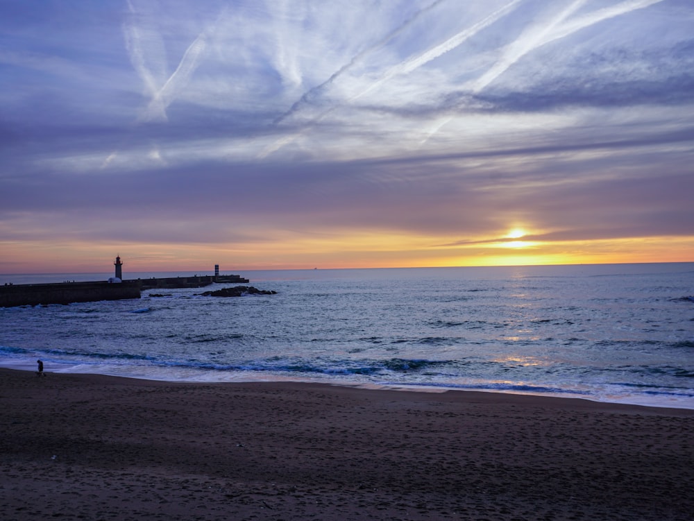 a person walking on a beach near the ocean