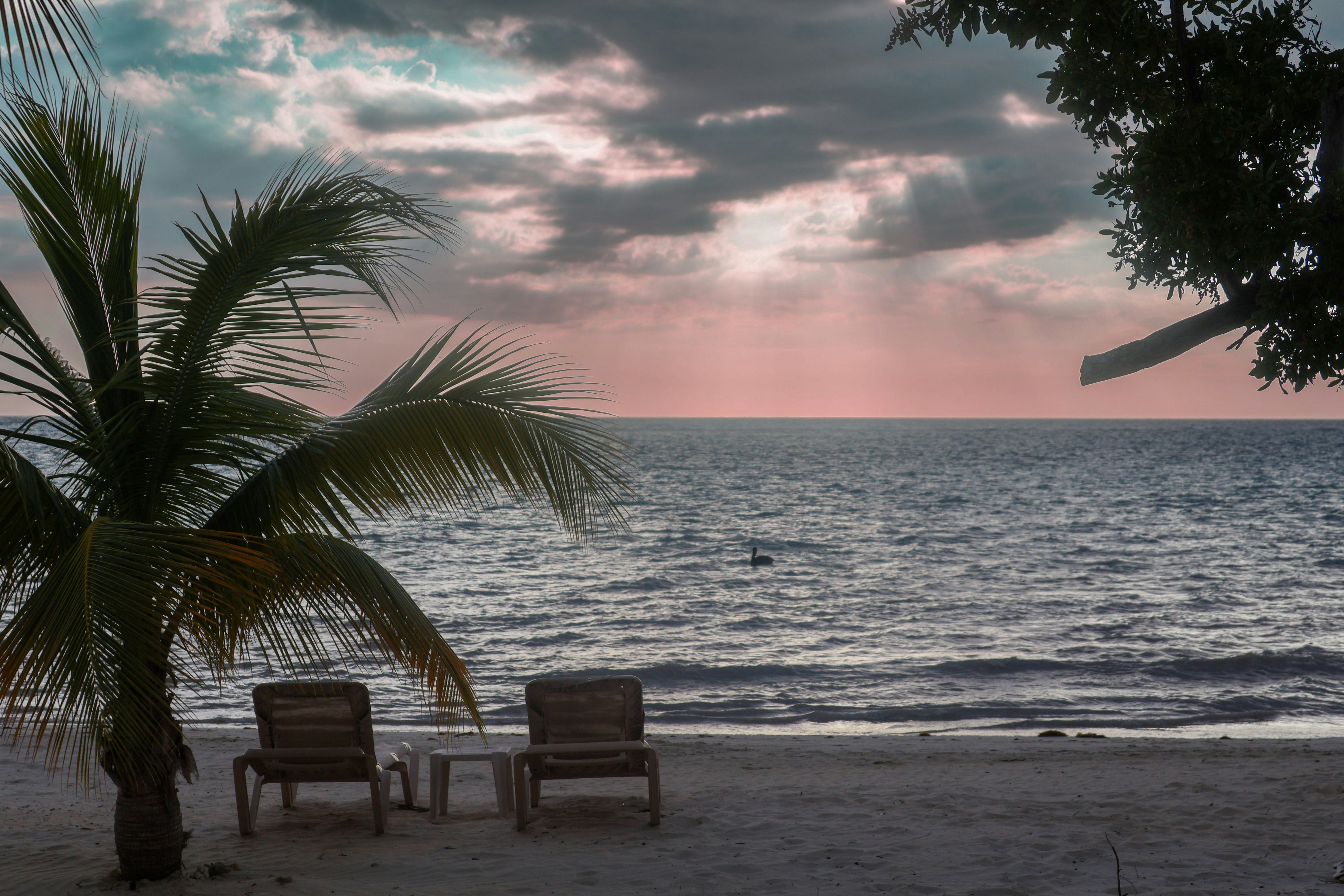 a couple of chairs sitting on top of a sandy beach, Sunset beach Sandals south coast