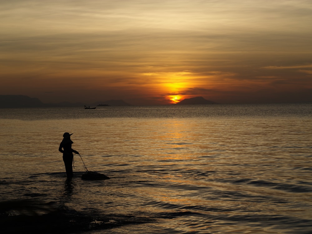 a person standing on a surfboard in the water