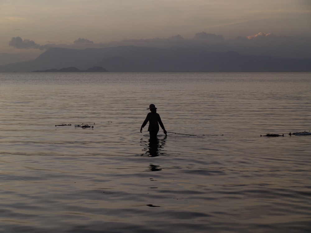 a person standing in the water with a surfboard