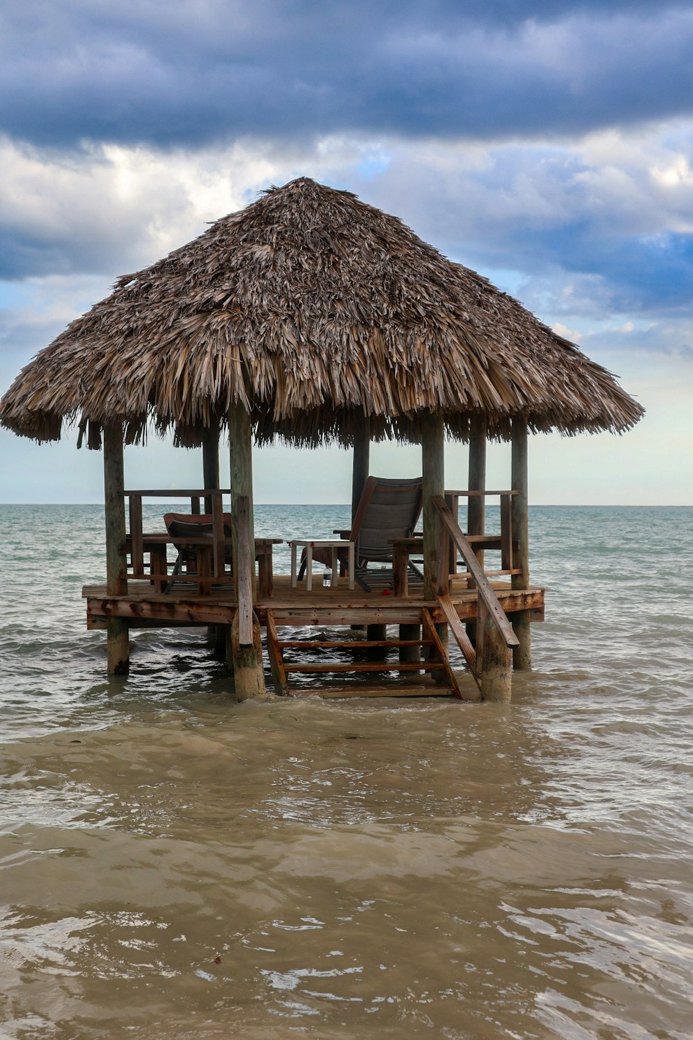 a hut with a thatched roof on the beach