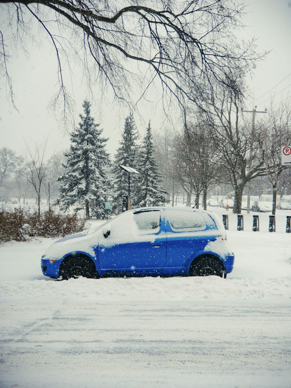 Un'auto blu è parcheggiata nella neve