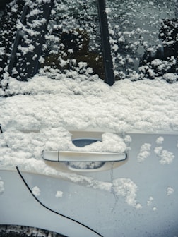 a car covered in snow with a door handle
