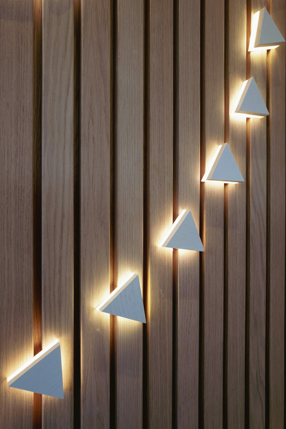 a group of white lights sitting on the side of a wooden wall