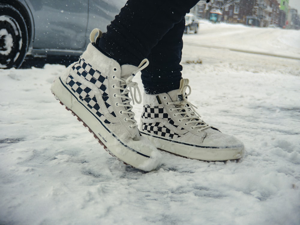 una persona in piedi nella neve con le scarpe