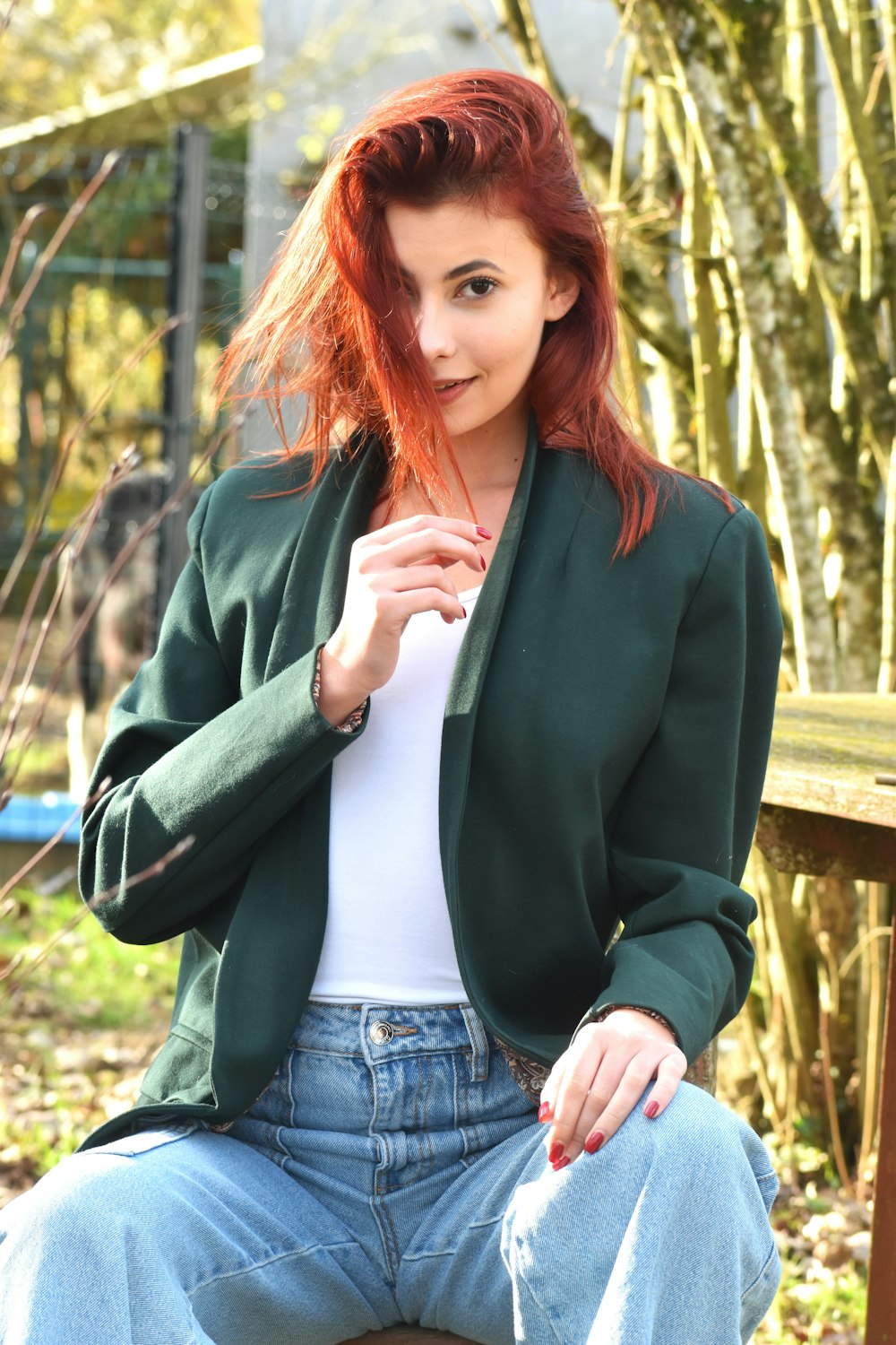 a woman with red hair sitting on a bench