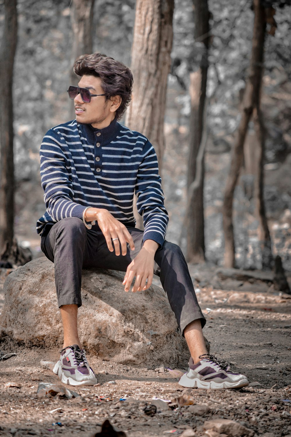 a man sitting on a rock in the woods