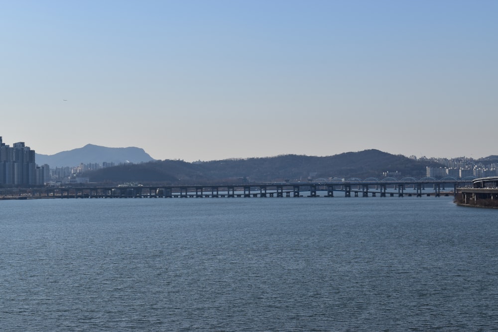 a large body of water with a bridge in the background