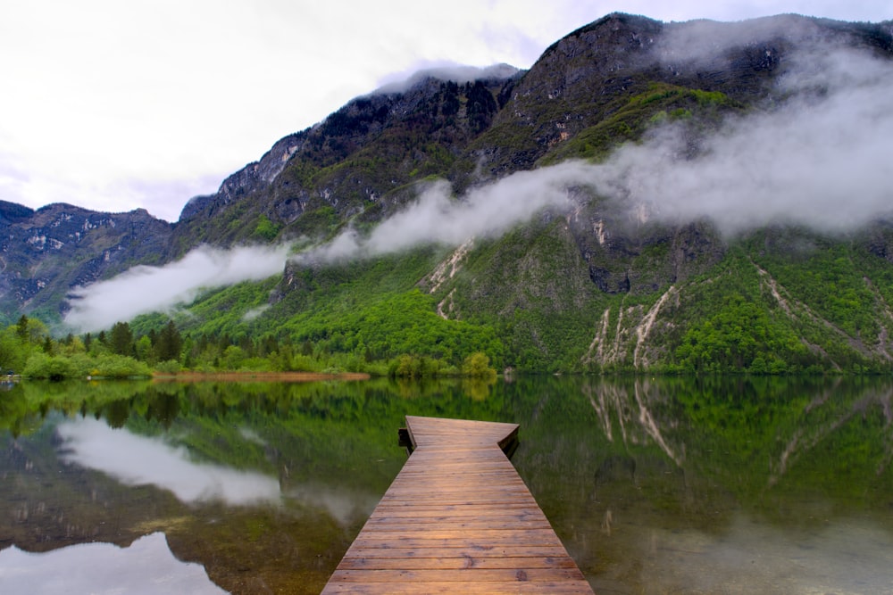 a dock on a lake with mountains in the background