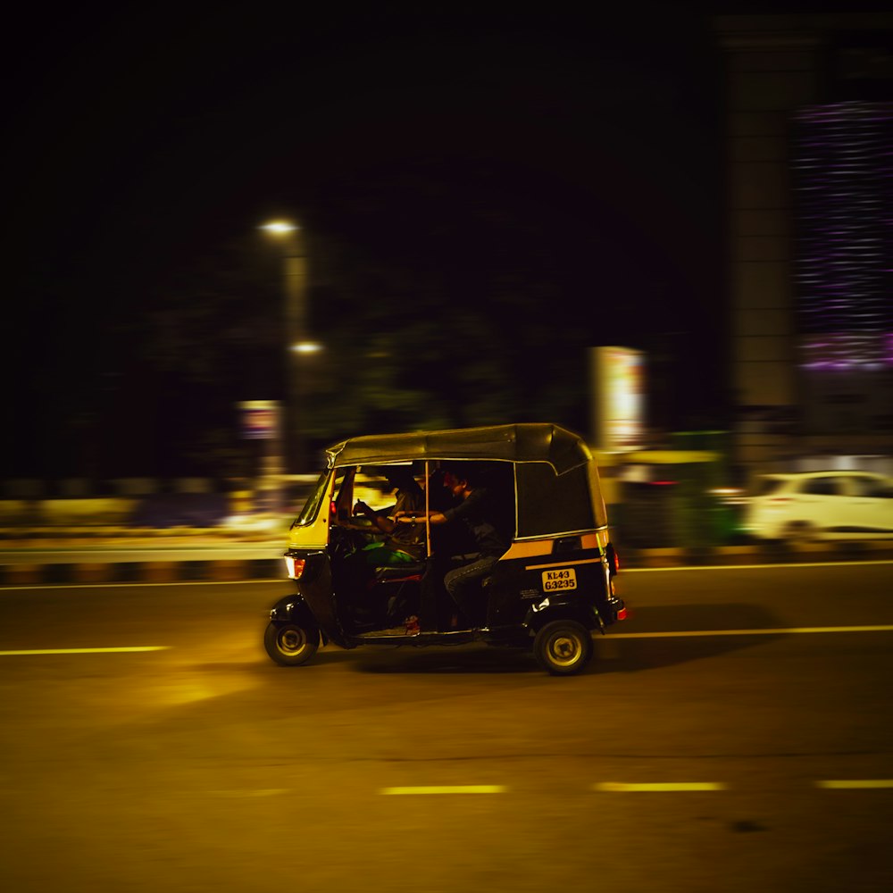 a golf cart driving down a street at night