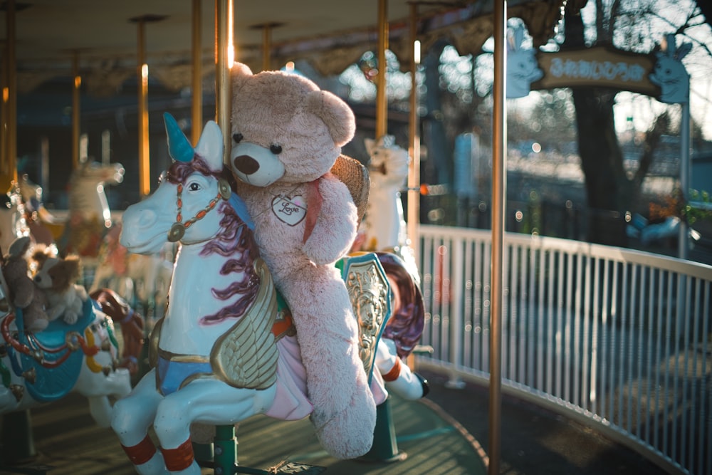 a teddy bear sitting on a merry go round