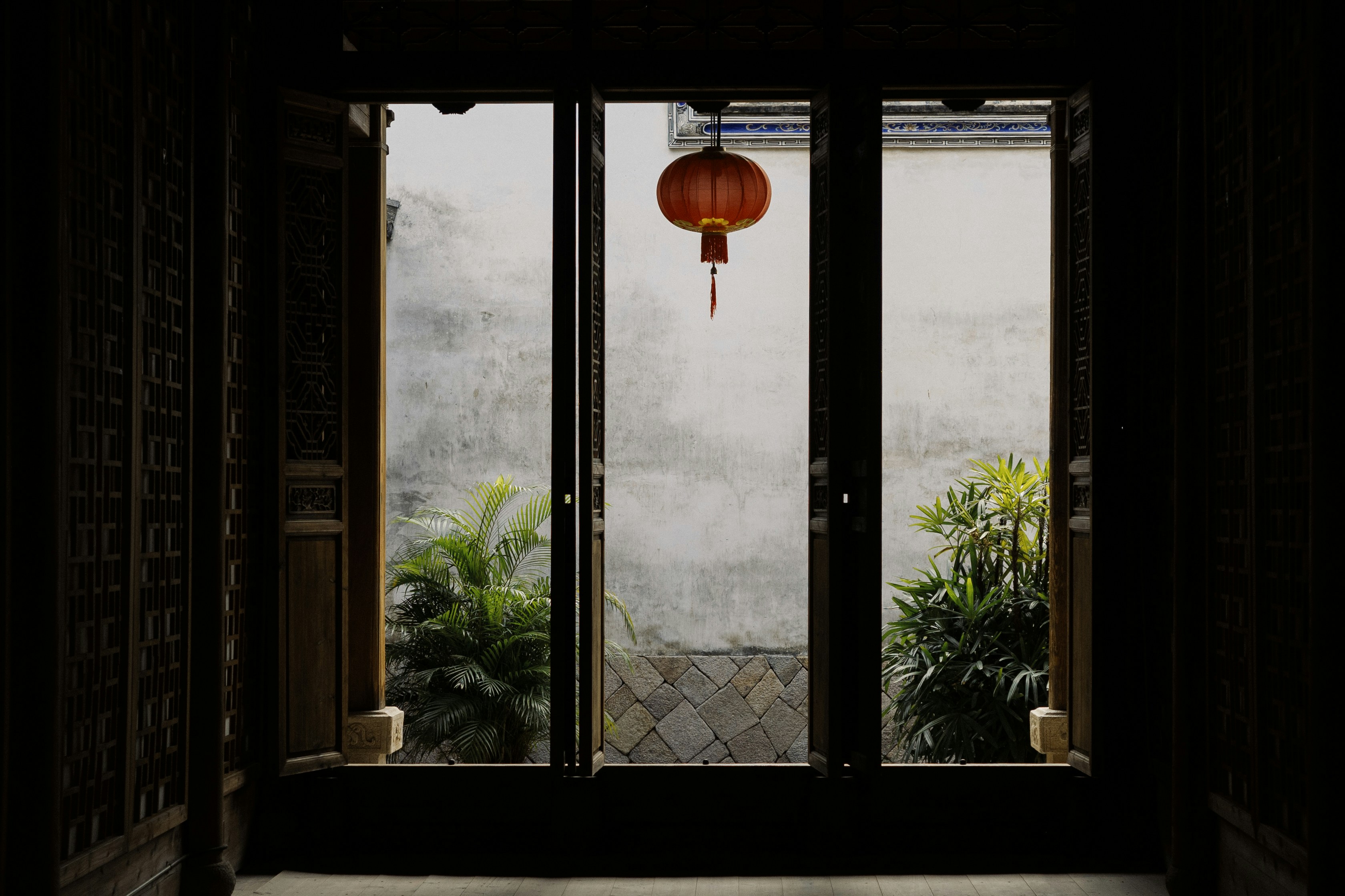 an open door with a red lantern hanging from it's side