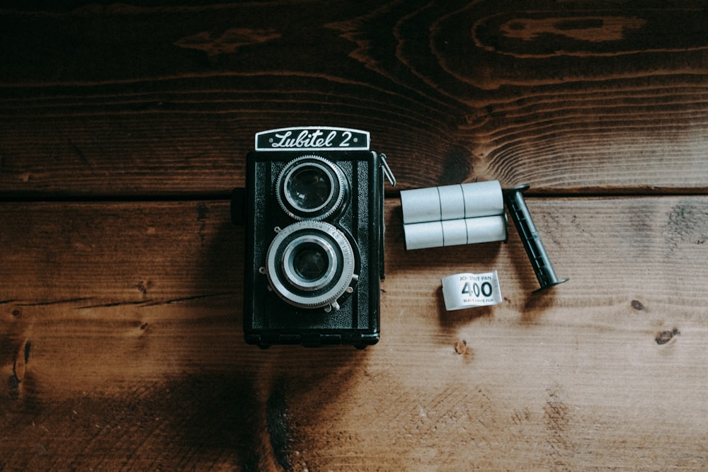 una cámara vieja con un rollo de cinta adhesiva al lado
