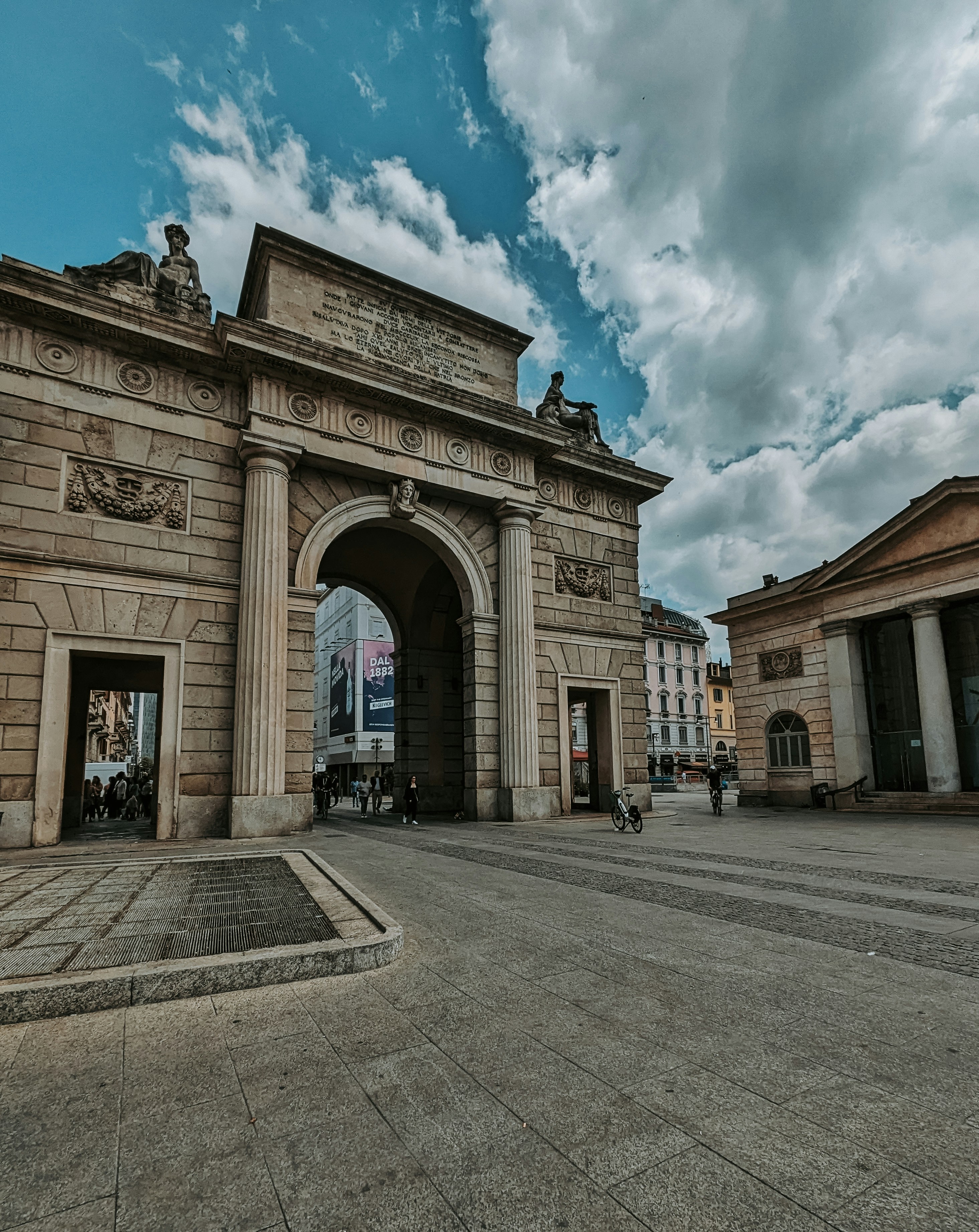 un grande arco in pietra con statue in cima
